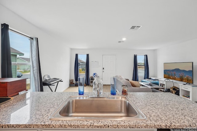 kitchen with light stone counters and sink