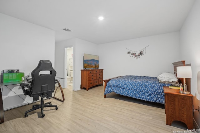 bedroom featuring ensuite bath and light wood-type flooring