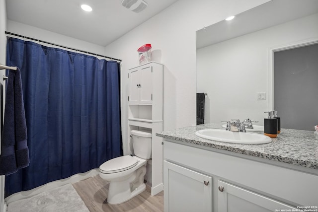 bathroom with vanity, hardwood / wood-style flooring, and toilet