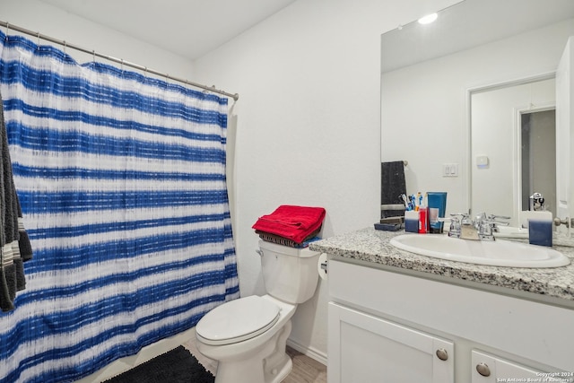 bathroom featuring vanity, toilet, and walk in shower