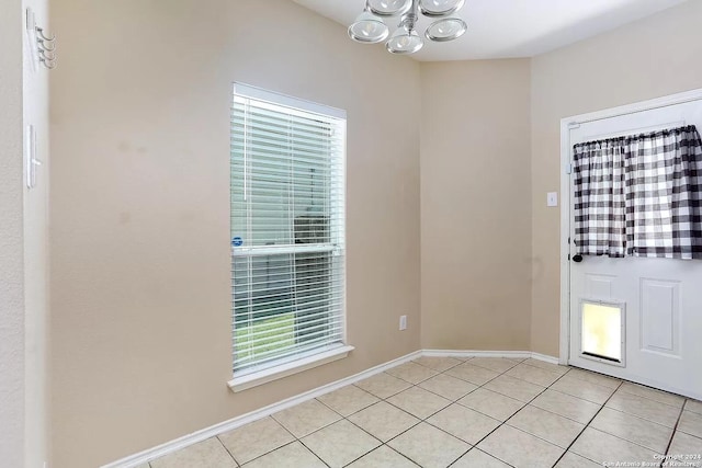 foyer featuring light tile patterned floors and a chandelier