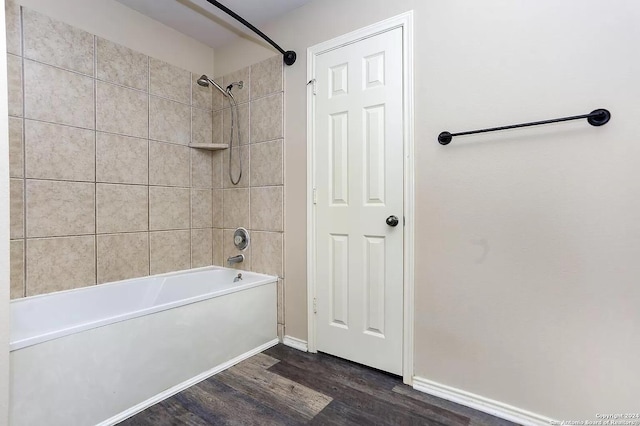 bathroom featuring wood-type flooring and tiled shower / bath