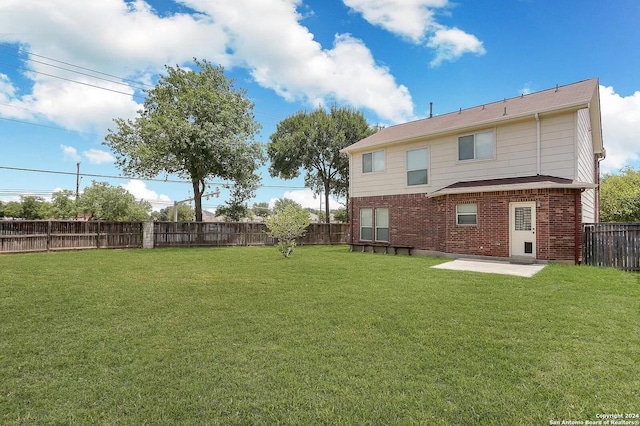 back of house featuring a lawn and a patio area