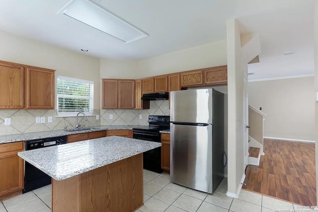 kitchen with backsplash, ventilation hood, sink, black appliances, and a kitchen island