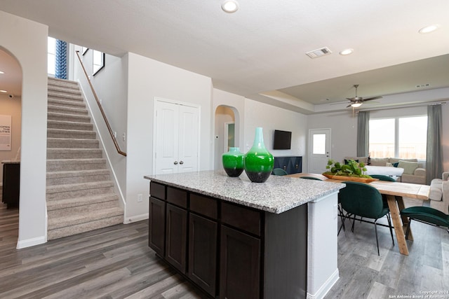 kitchen featuring dark brown cabinetry, ceiling fan, a center island, and hardwood / wood-style flooring