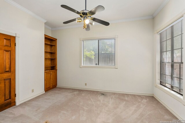 unfurnished bedroom with light carpet, multiple windows, ornamental molding, and ceiling fan