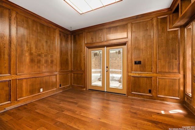 spare room with french doors, dark hardwood / wood-style floors, and wood walls