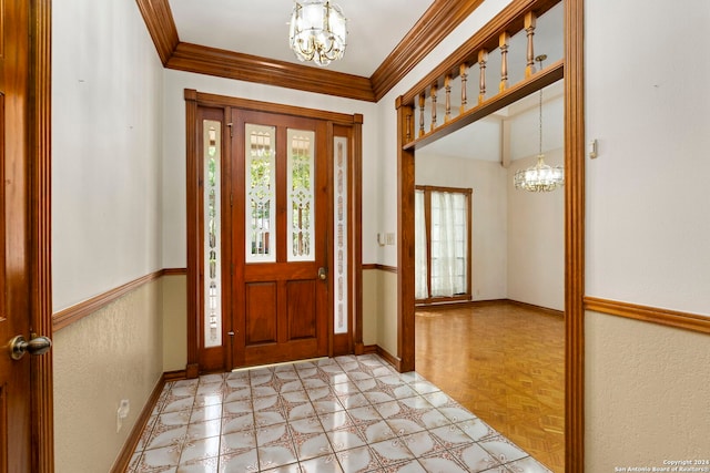 foyer with light parquet flooring, ornamental molding, and a notable chandelier