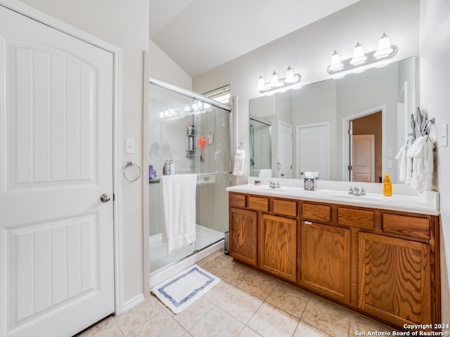 bathroom featuring tile patterned flooring, vanity, a shower with door, and vaulted ceiling