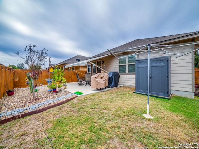 rear view of house with a lawn, a patio area, and a storage shed