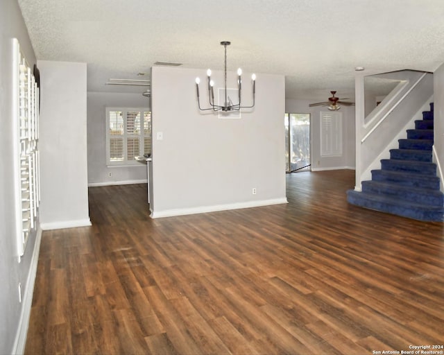 unfurnished dining area featuring a textured ceiling, ceiling fan with notable chandelier, and dark hardwood / wood-style floors