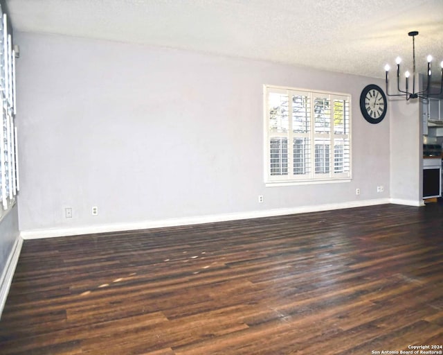 interior space with dark hardwood / wood-style flooring, a textured ceiling, and an inviting chandelier