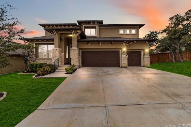 prairie-style home featuring a lawn and a garage