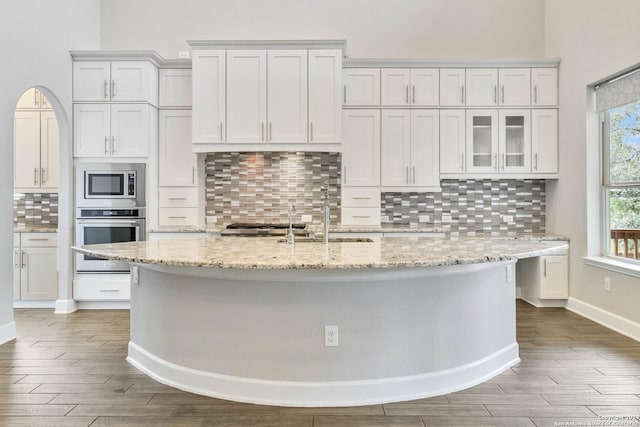 kitchen with white cabinets, backsplash, and stainless steel appliances