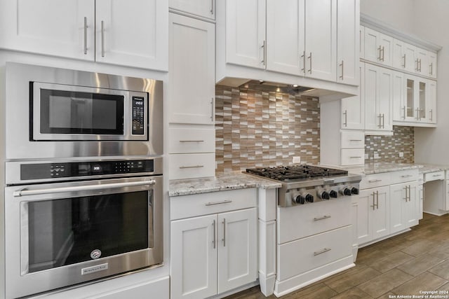 kitchen featuring backsplash, white cabinetry, and stainless steel appliances