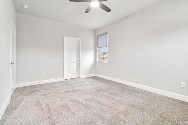 carpeted spare room featuring ceiling fan