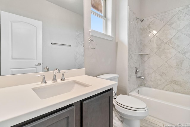 full bathroom featuring vanity, tiled shower / bath combo, and toilet