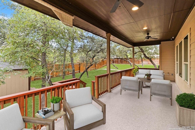 wooden terrace with ceiling fan, a yard, and an outdoor living space