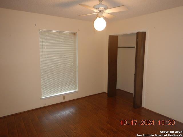 unfurnished bedroom featuring ceiling fan, a closet, and dark hardwood / wood-style floors