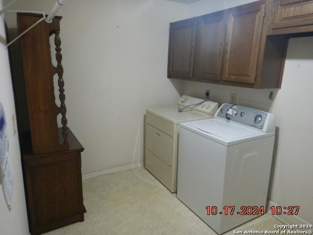 laundry room featuring washing machine and clothes dryer and cabinets