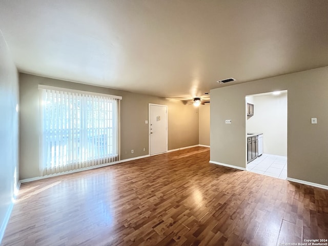 unfurnished living room featuring ceiling fan and light hardwood / wood-style floors