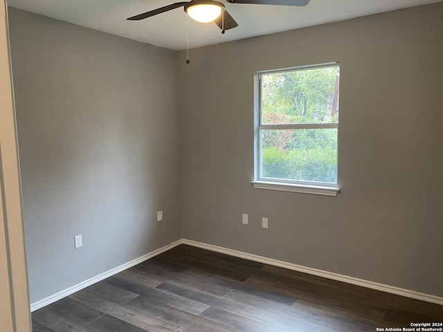 unfurnished room with dark wood-type flooring, ceiling fan, and a healthy amount of sunlight