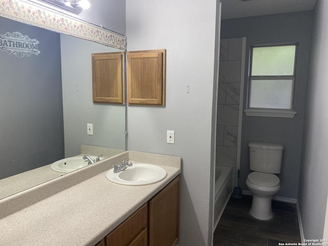 full bathroom with shower / bath combination, vanity, wood-type flooring, and toilet