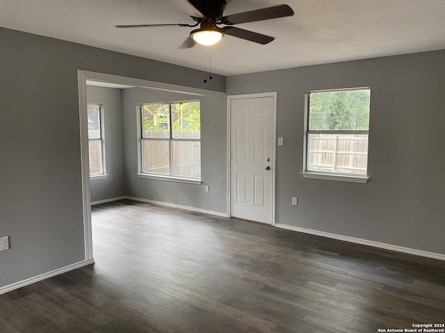 unfurnished room with plenty of natural light, dark wood-type flooring, and ceiling fan