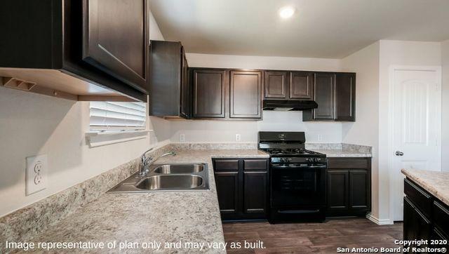 kitchen featuring light stone countertops, dark brown cabinetry, sink, black gas range, and dark hardwood / wood-style floors