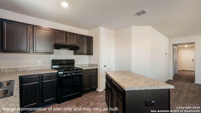 kitchen with black gas range, sink, dark hardwood / wood-style flooring, dark brown cabinets, and a kitchen island