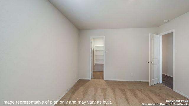 unfurnished bedroom featuring a spacious closet, a closet, and light colored carpet