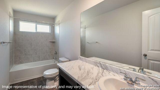 full bathroom with vanity, tiled shower / bath combo, hardwood / wood-style flooring, and toilet