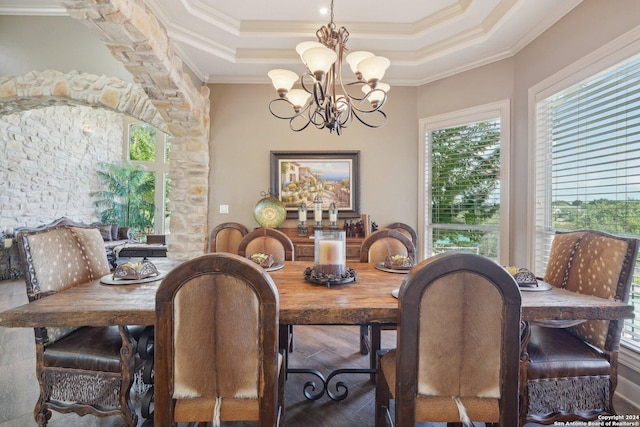 dining space with a tray ceiling, an inviting chandelier, and ornamental molding