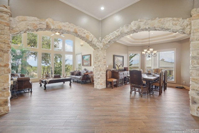 dining room with a wealth of natural light, a towering ceiling, and hardwood / wood-style flooring