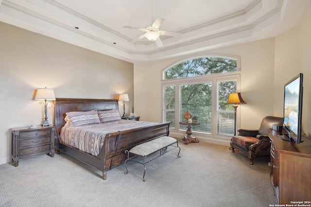 bedroom with a raised ceiling, ceiling fan, light carpet, and ornamental molding