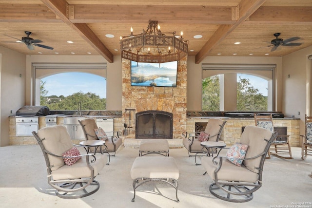 view of patio with area for grilling, ceiling fan, exterior kitchen, and an outdoor stone fireplace