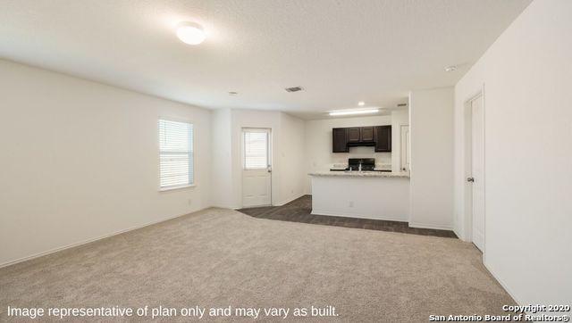 unfurnished living room with dark colored carpet