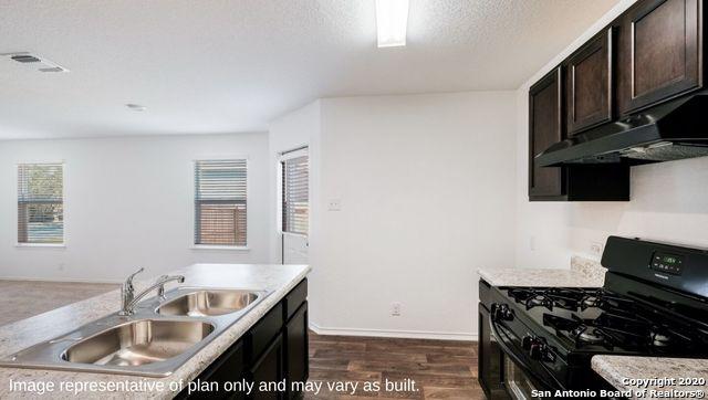 kitchen with black range with gas stovetop, a wealth of natural light, dark brown cabinetry, and dark hardwood / wood-style floors