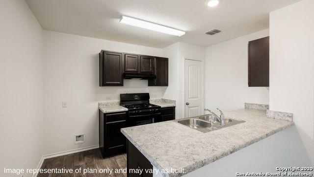 kitchen featuring sink, black range with gas stovetop, dark hardwood / wood-style floors, kitchen peninsula, and dark brown cabinets