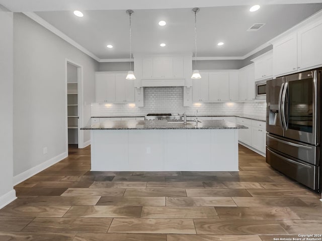 kitchen with white cabinets, appliances with stainless steel finishes, and a kitchen island with sink