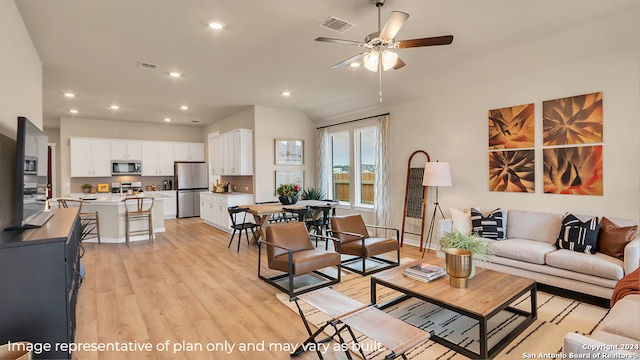 living room with light wood-type flooring, ceiling fan, and lofted ceiling