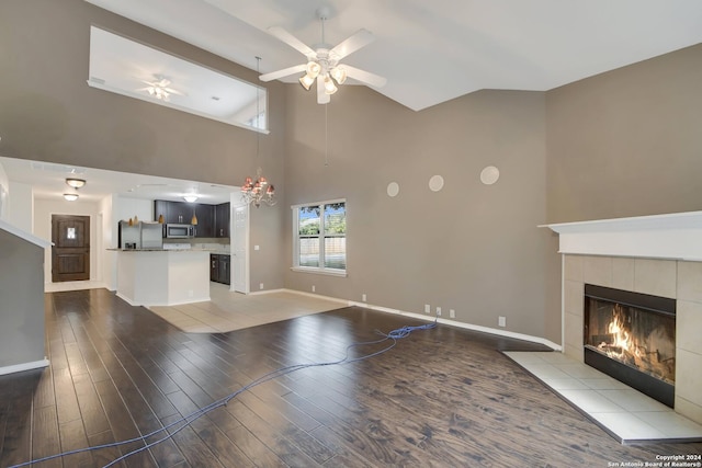 unfurnished living room featuring a fireplace, ceiling fan, hardwood / wood-style floors, and high vaulted ceiling