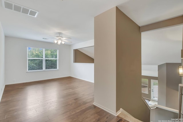 unfurnished living room featuring ceiling fan and dark wood-type flooring