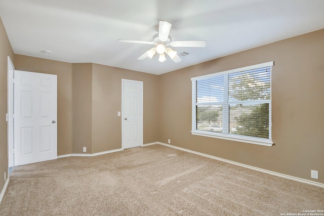 carpeted spare room featuring ceiling fan