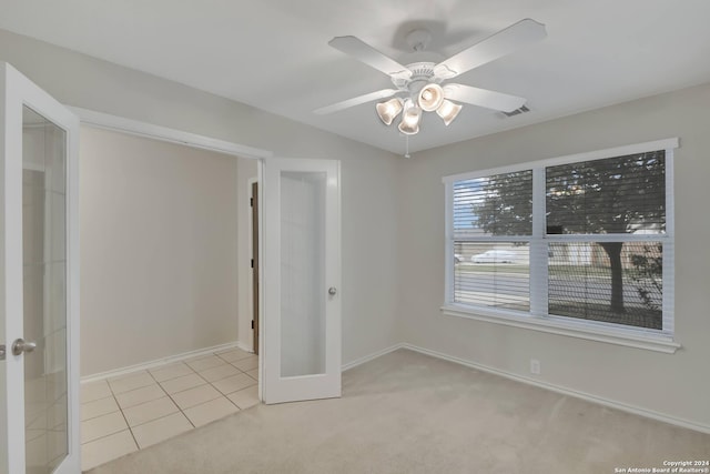 carpeted empty room with ceiling fan and french doors