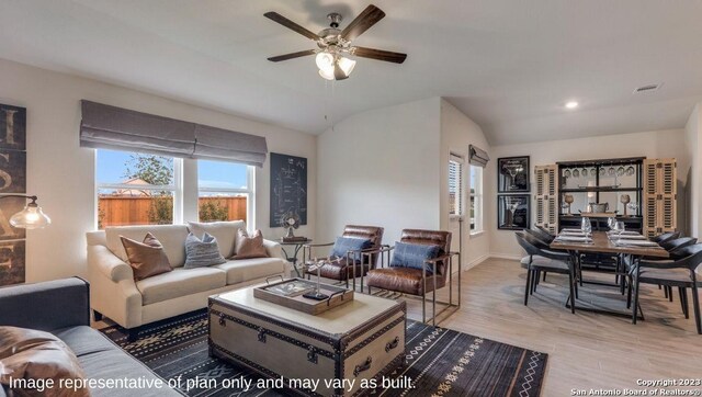 living room featuring ceiling fan, light hardwood / wood-style floors, and lofted ceiling