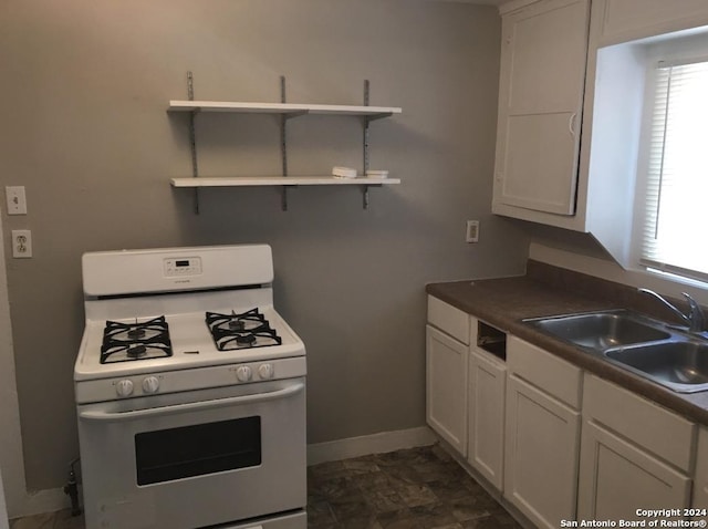 kitchen featuring white cabinets, white gas range, and sink