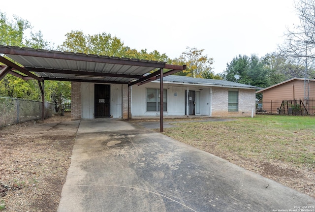 ranch-style house featuring a carport, a porch, and a front yard