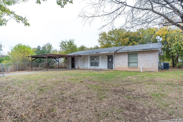 ranch-style house with cooling unit, a front yard, and a carport