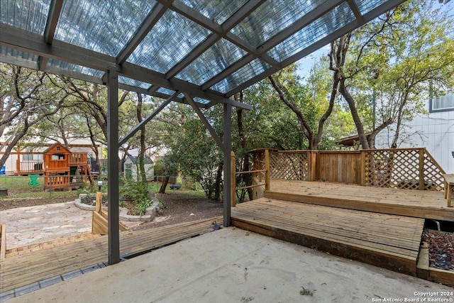 wooden terrace with a patio area and a playground